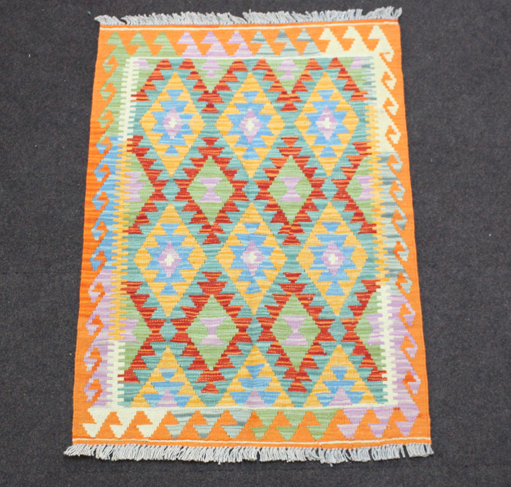 A yellow, green and orange ground Chobi Kilim rug with all over geometric design 119cm x 81cm