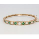 A 9ct yellow gold bangle set opals and emeralds 13.4 grams