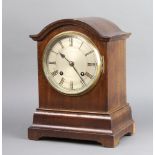 An Edwardian striking bracket clock with silvered dial and Roman numerals contained in an arch