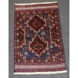 A brown, blue and red ground Belouche rug 139cm x 91cm