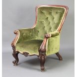 A Victorian mahogany show frame armchair upholstered in green buttoned material raised on carved