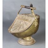 A Benham & Froud Victorian embossed brass helmet shaped coal scuttle with turned wooden handle (