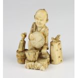 A carved ivory Okimono of a seated chef 5.5cm