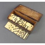 A set of 28, 19th Century bone and ebony dominoes, contained in a wooden box with hinged lid which