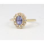 An 18ct yellow gold oval amethyst and diamond cluster ring, centre stone approx. 0.75ct,