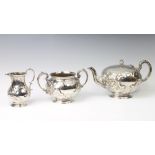 A Victorian silver 3 piece tea set with repousse floral decoration and vacant cartouches London