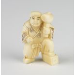 A Meiji period ivory Netsuke in the form of a standing gentleman with giant mallet, signed 5cm