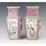 A pair of 18th Century style Chinese pink ground hexagonal tapered vases decorated with panels of