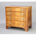 A Georgian style walnut chest of 4 long drawers with oval plate drop handles, raised on bracket feet