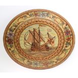 A Portuguese ceramic charger decorated with a galleon enclosed in a floral border 38cm
