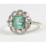 An 18ct yellow gold emerald and diamond cluster ring, the centre stone approx 0.7ct surrounded by 10