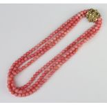 A string of 3 coral coloured beads with a silver gilt clasp 42cm