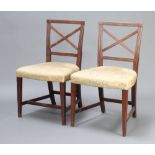 A pair of Georgian mahogany dining chairs with X framed backs and over stuffed seats raised on