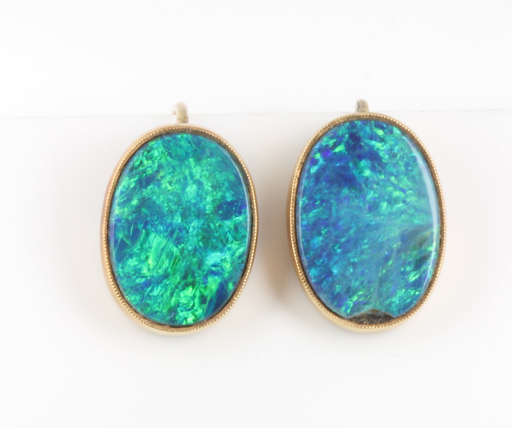 A pair of yellow gold and black opal oval earrings 15mm x 10cmm One opal has a small chip to the