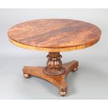 A William IV circular mahogany snap top breakfast table raised on a carved column and triform base