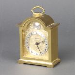 Swiza, a Swiss 8 day alarm clock contained in a Queen Anne style gilt metal case, the dial with