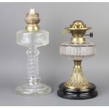 A Victorian faceted glass oil lamp reservoir raised on an embossed gilt metal base with ceramic