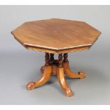 A Victorian octagonal walnut snap top occasional table raised on 4 turned columns and outswept