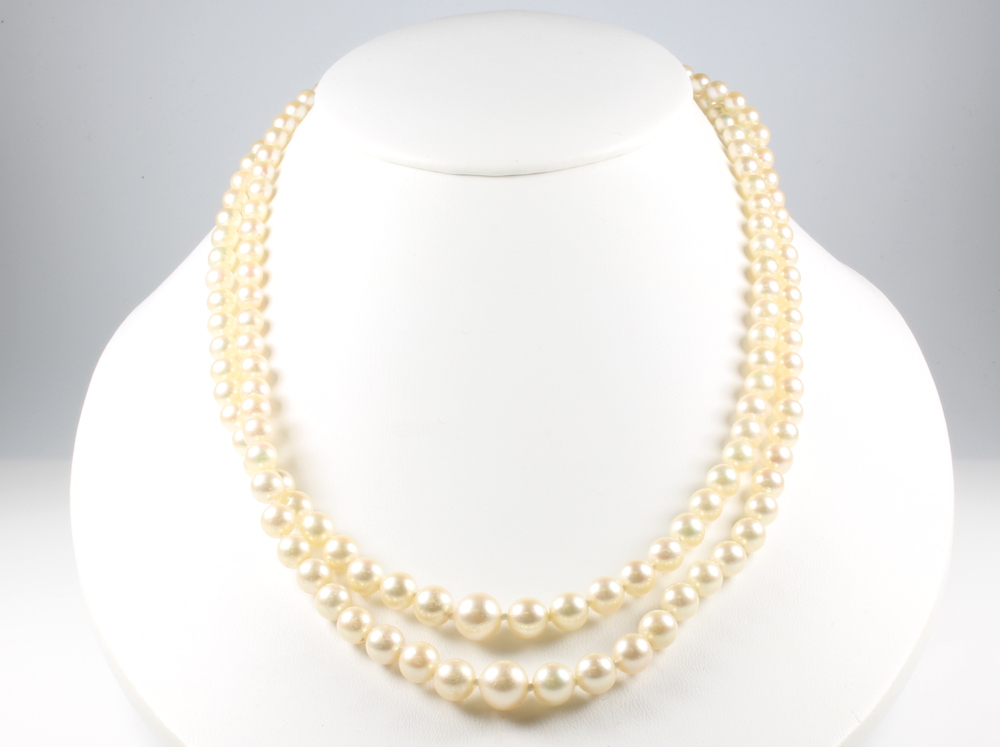 A double strand of cultured pearls with a 9ct yellow gold cabochon garnet and seed pearl clasp 46cm