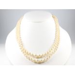 A double strand of cultured pearls with a 9ct yellow gold cabochon garnet and seed pearl clasp 46cm