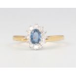 An 18ct yellow gold oval sapphire and diamond cluster ring, sapphire approx. 0.5ct, diamonds 0.25ct,