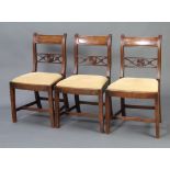 A set of 3 19th Century mahogany bar back dining chairs with pierced and carved mid rails, raised on