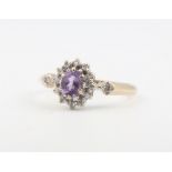 A 9ct yellow gold oval amethyst and diamond cluster ring size, 1.9 grams, K 1/2