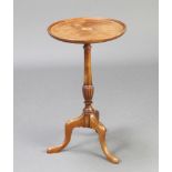 An Edwardian circular bleached mahogany wine table raised on a turned column and tripod base 52cm