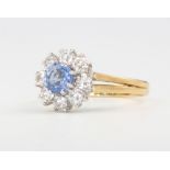 An 18ct yellow gold sapphire and diamond cluster ring, centre stone approx. 0.65ct surrounded by 8