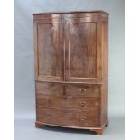 A 19th Century mahogany bow front linen press with moulded cornice, enclosed by panelled doors above