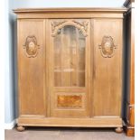 An Edwardian Dutch carved oak bookcase, fitted shelves, the centre section enclosed by arched