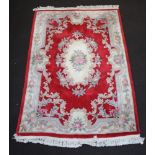 A white and red floral patterned Chinese carpet with central medallion 253cm x 166cm Some light moth