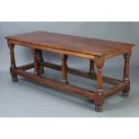 A rectangular oak library table raised on 8 turned doric columns with box stretcher and bun feet