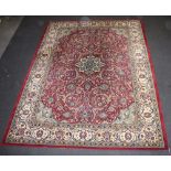 A red and white floral patterned machine made Persian style carpet with central medallion 347cm x