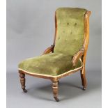 A Victorian mahogany show frame nursing chair upholstered in green buttoned material, raised on