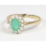 An 18ct yellow gold oval emerald and diamond cluster ring, size P, 3.3 grams