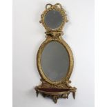 A Victorian arched plate mirror contained in a painted gilt frame, upper section with circular plate