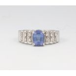 An 18ct white gold tanzanite and diamond dress ring, the oval stone approx. 1.5ct set with 12