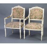 A pair of French Empire style white painted open arm salon chairs with upholstered seats and