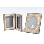 A modern repousse silver oval photograph frame, rubbed marks, a double folding ditto