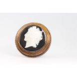 A Victorian circular carved hardstone cameo portrait brooch contained in an Etruscan style frame