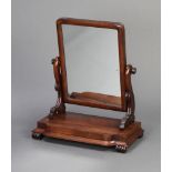 A William IV rectangular plate dressing table mirror contained in a mahogany swing frame, raised