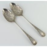A matched pair of George III silver berry spoons with floral decoration, London 1809 and 1811, 126