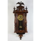 A striking Vienna style regulator with paper dial and Roman numerals, having a grid iron pendulum,