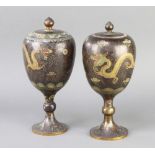 A near pair of Japanese black ground cloisonne enamelled urns and covers decorated running dragons