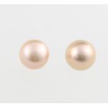 A pair of pink cultured pearl ear studs with 9ct yellow gold mounts