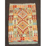 A green, tan and yellow ground Chobi Kilim rug with 2 diamonds to the centre and all over
