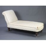 A Victorian chaise longue/day bed upholstered in floral patterned material, raised on turned