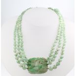 A good Chinese carved jade necklace with triple bead strands and a rectangular plaque carved with