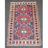 A red, white and blue ground Afghan rug with 3 stylised diamonds to the centre within a multi row